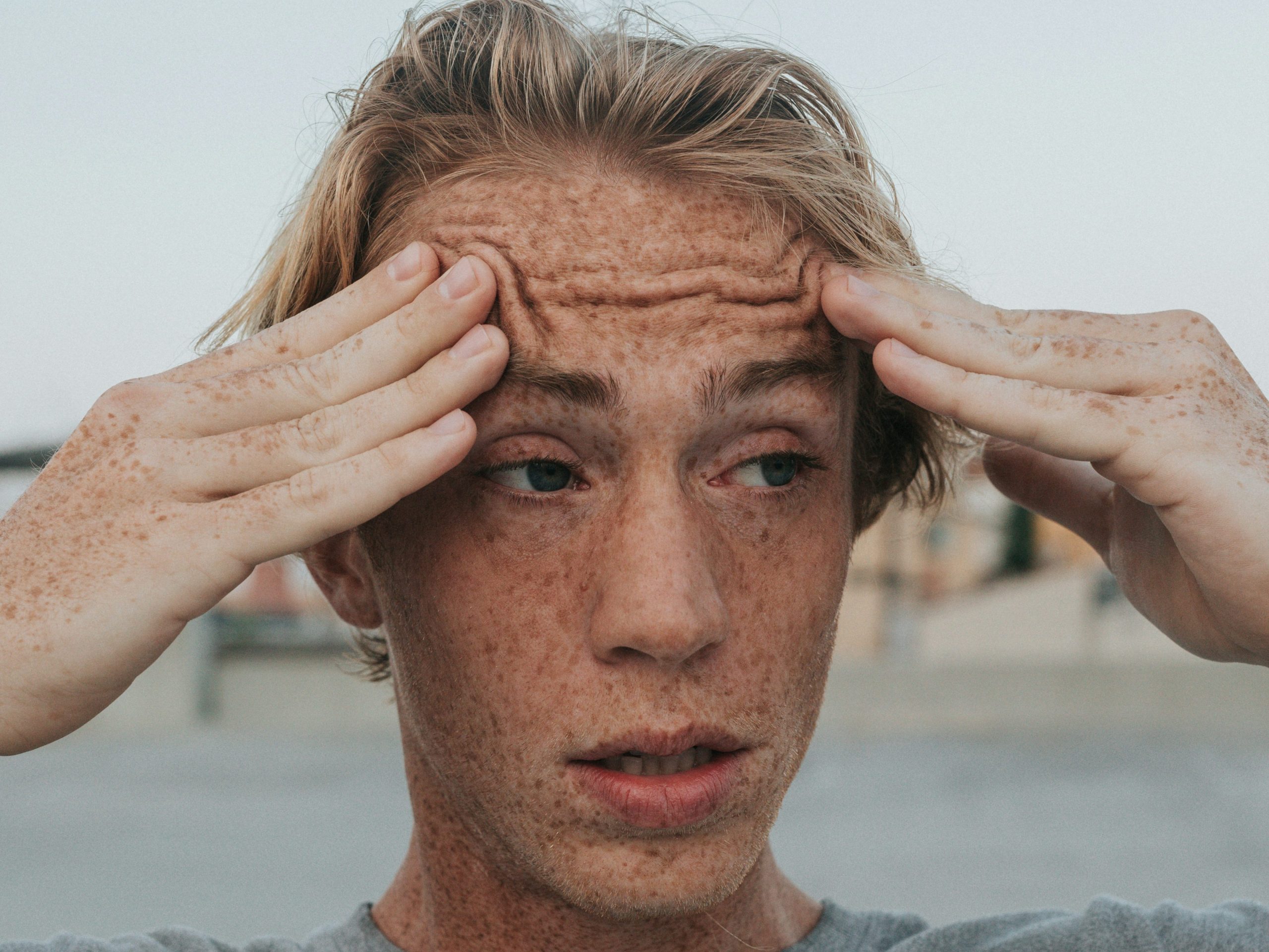 Confused man touching his forehead with both his hands 